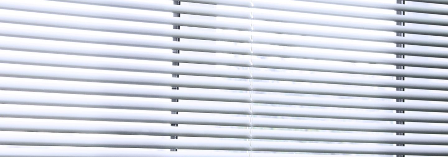A Close Up Of A White Blind On A Window — Ron Ayton Curtains, Blinds & Shutters In Shelly Beach, NSW