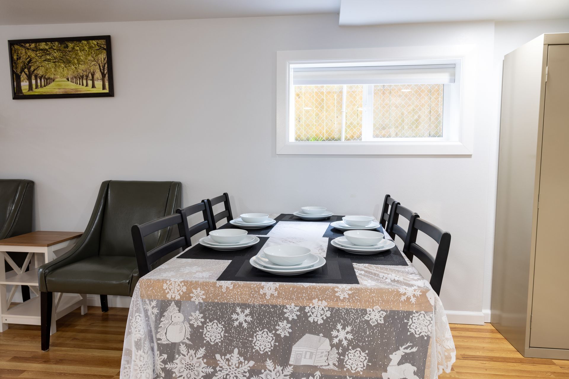Dining room with table set for six, a window, artwork, and chairs.