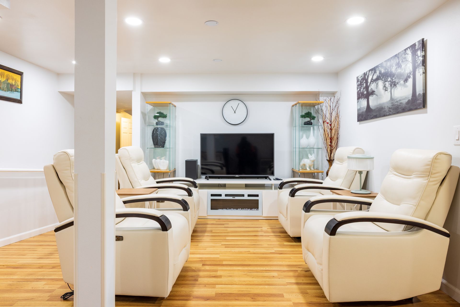 Living room with recliner chairs facing a large TV and fireplace.