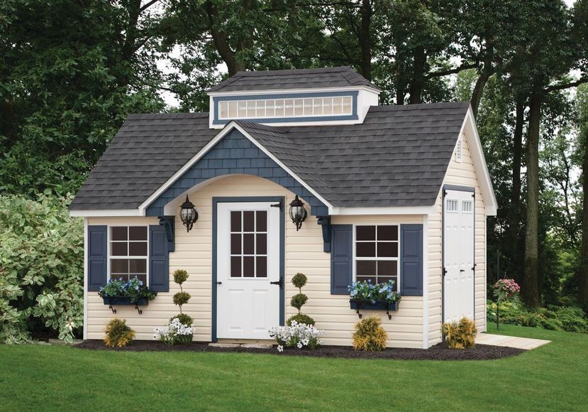 A small white house with blue shutters and a black roof