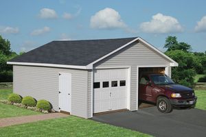 A red truck is parked in a garage with a white door.