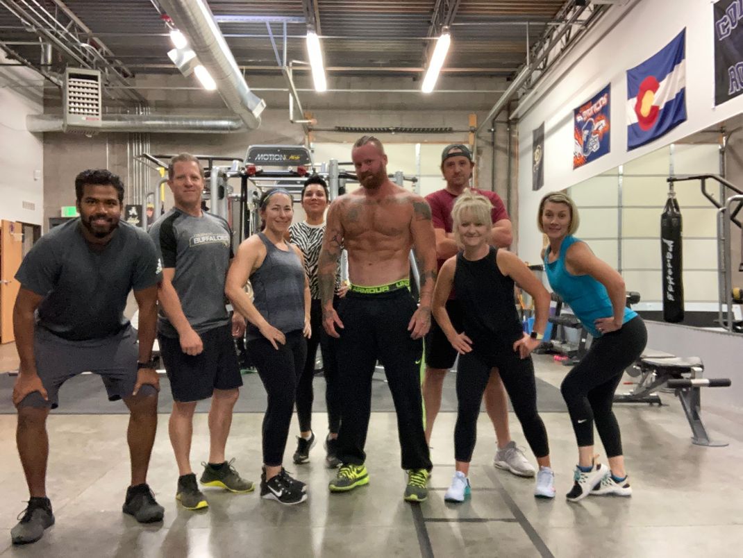 A group of people are posing for a picture in a gym.