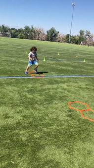 A young boy is running on a soccer field.