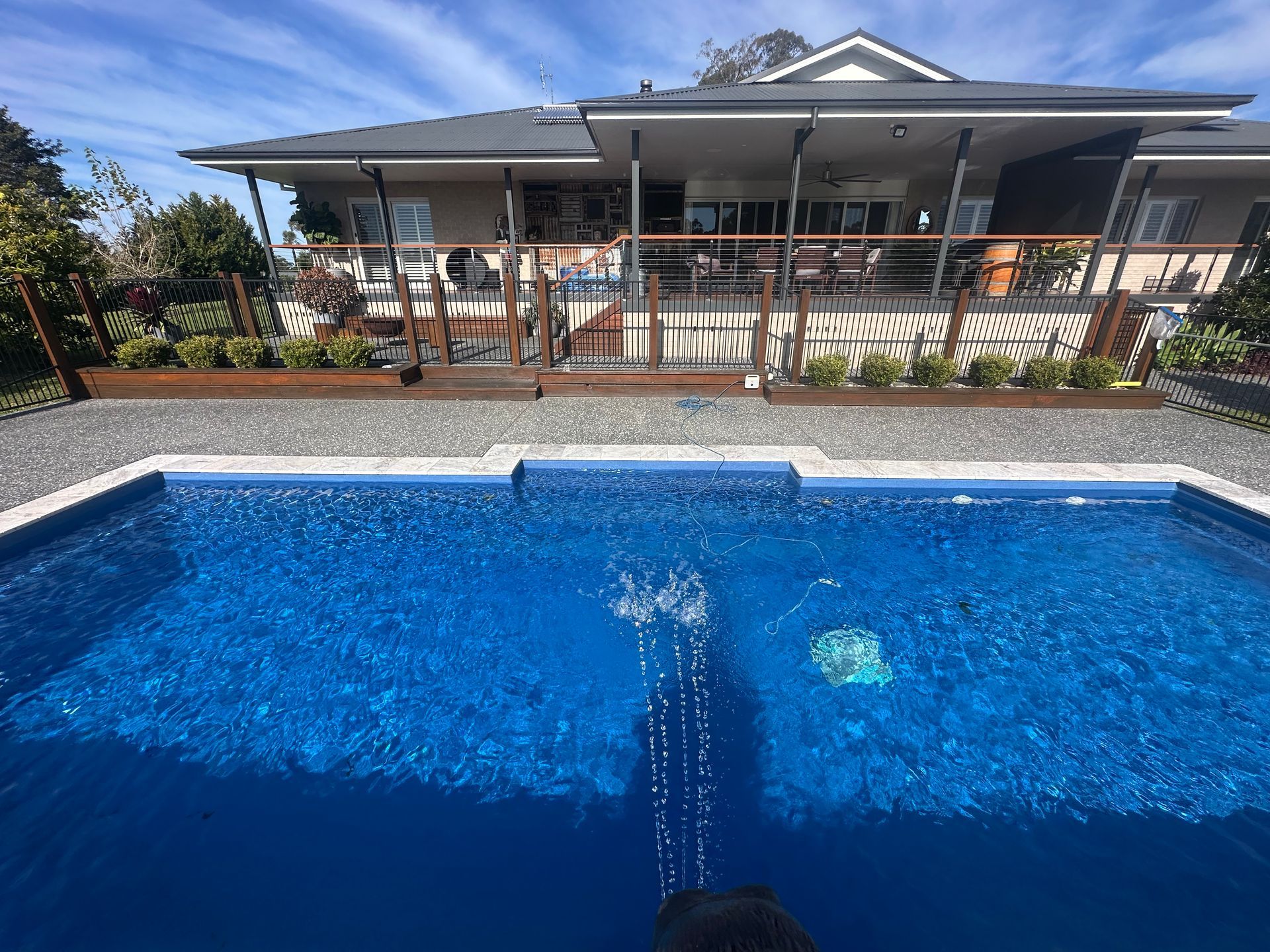 A large house with a swimming pool in front of it. — Steve Merrick Family Swimming Pools in Forster, NSW