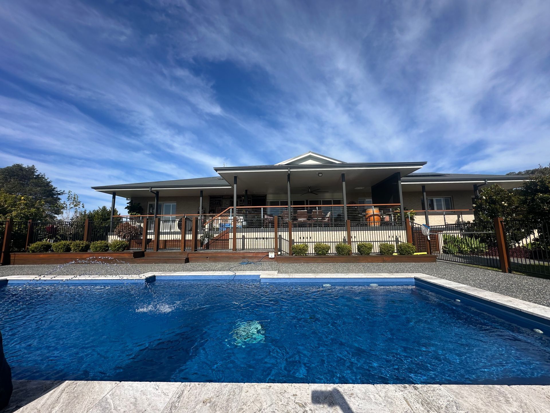 A large house with a large swimming pool in front of it. — Steve Merrick Family Swimming Pools in Failford, NSW