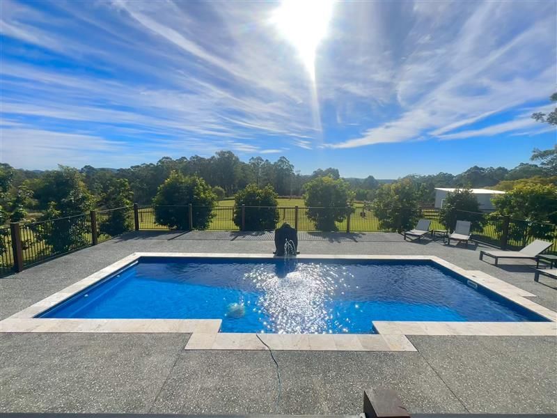 A large swimming pool with a fountain in the middle — Steve Merrick Family Swimming Pools in Failford, NSW