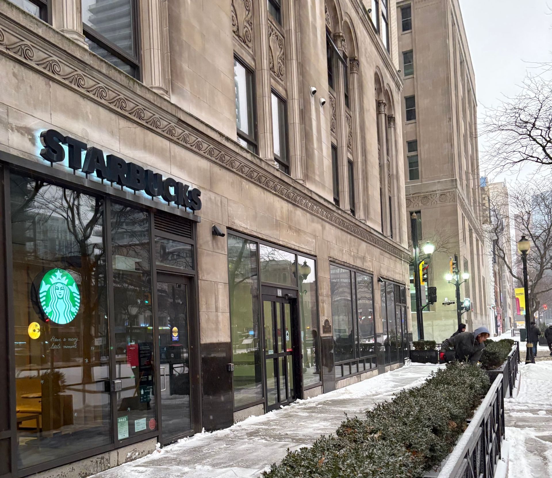 A snow plow is plowing snow on a city street.