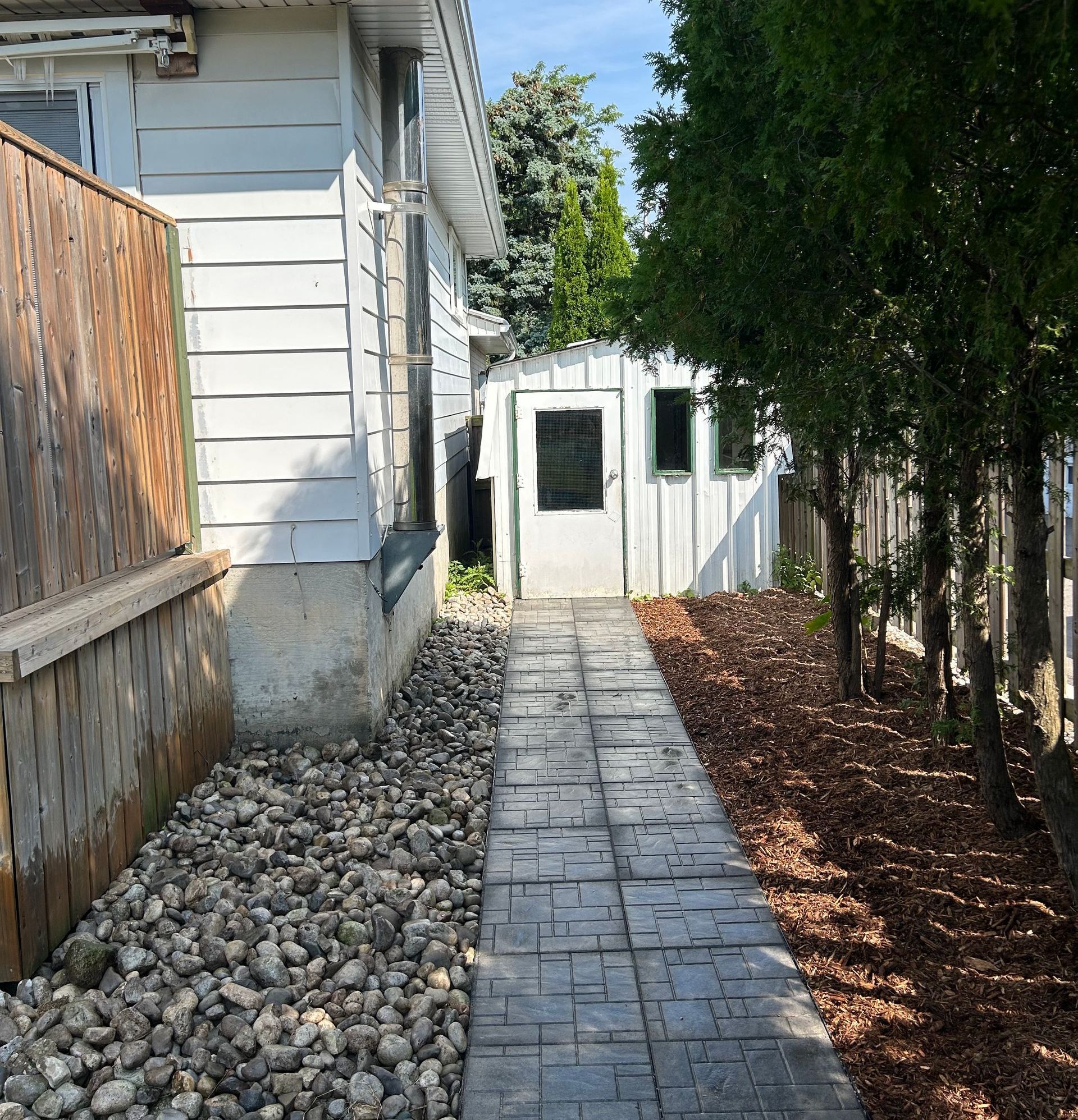 A brick walkway leading to a white house
