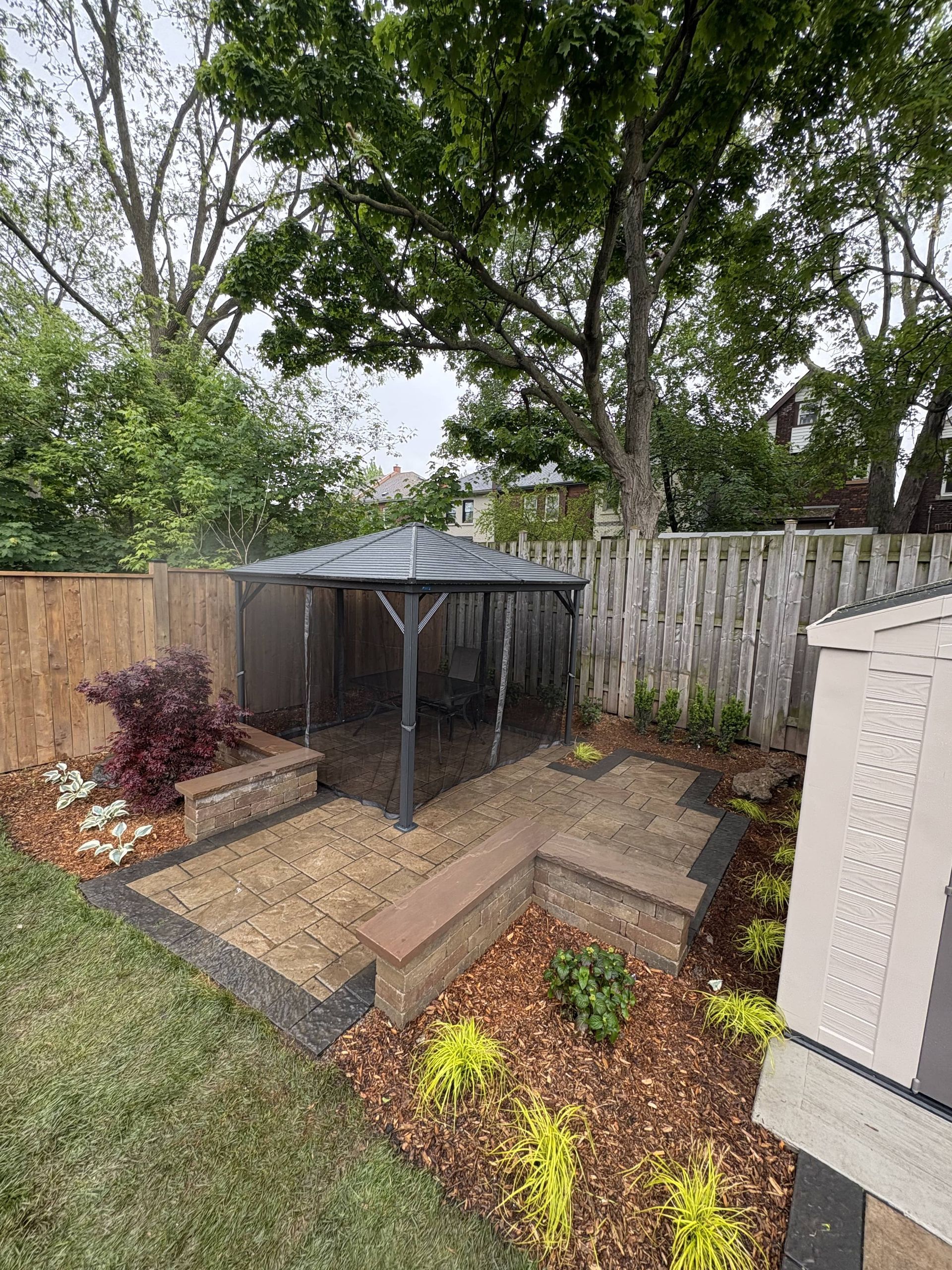 There is a gazebo in the backyard of a house.