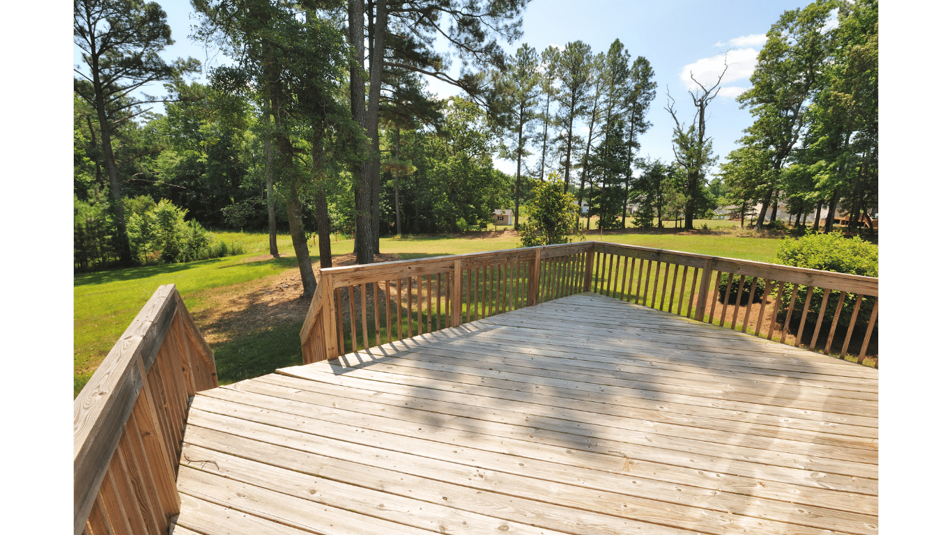 A wooden deck with trees in the background