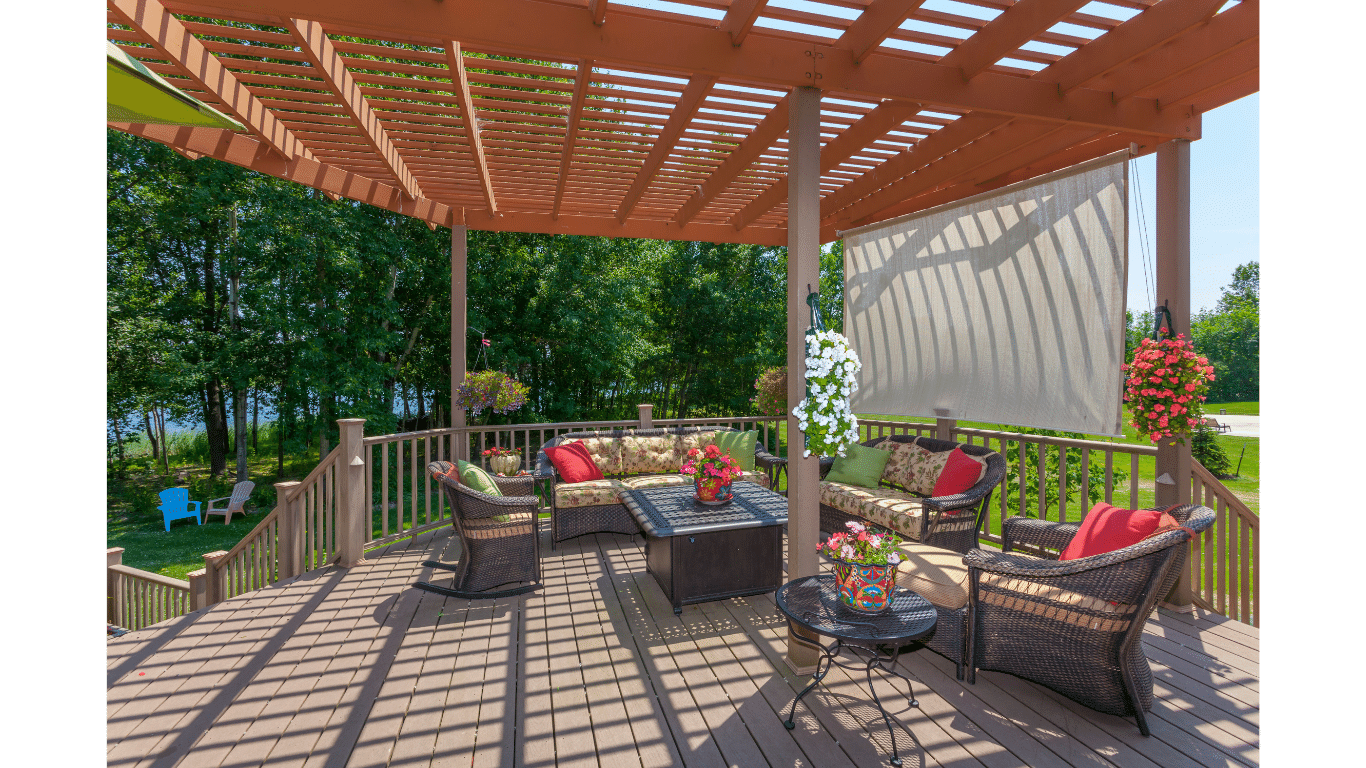 A wooden deck with a pergola and wicker furniture.