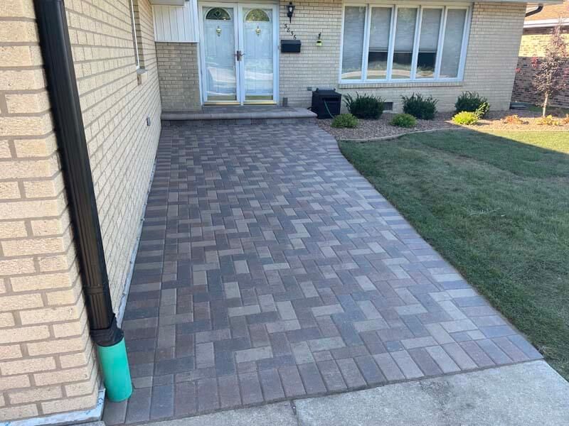 A brick walkway leading to the front door of a house.