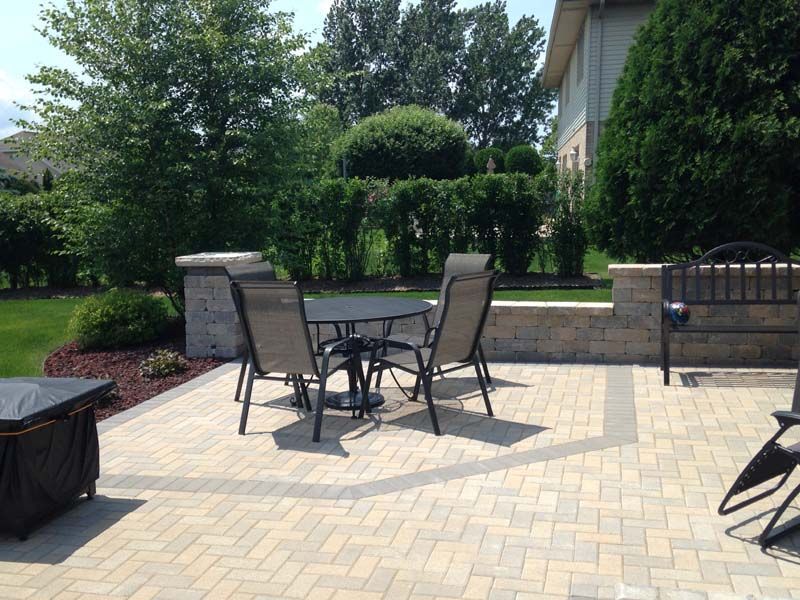 A patio with a table and chairs and a fire pit.