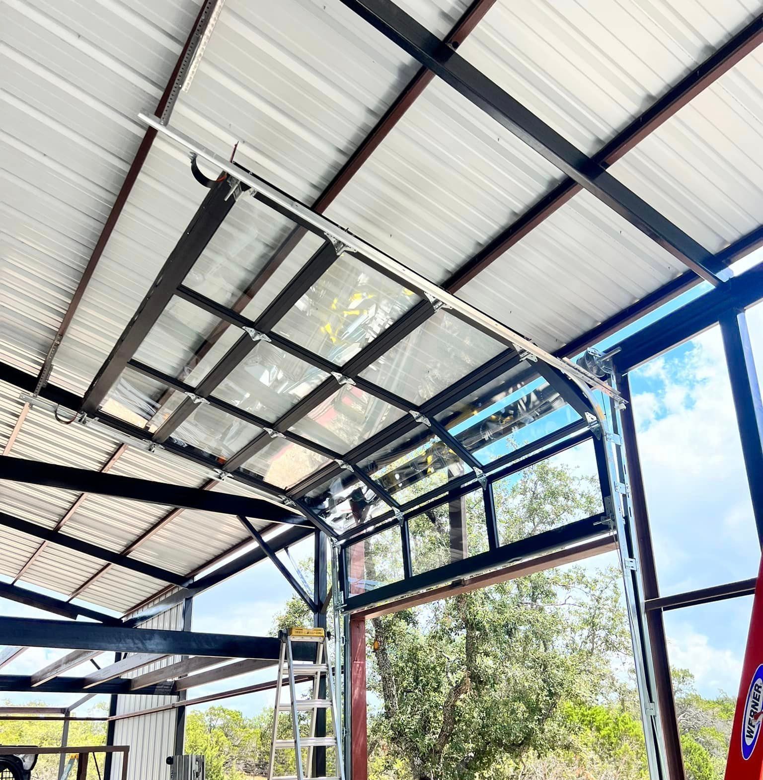 A garage door is open and a ladder is in the background.