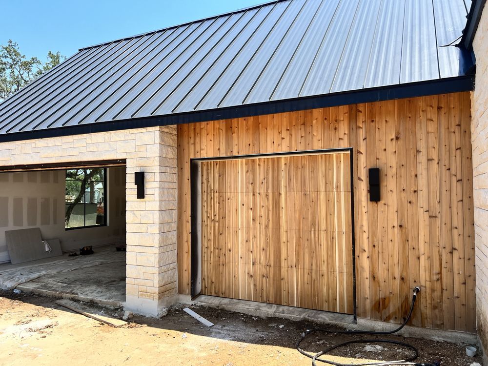A house with a metal roof and wooden siding is being built.