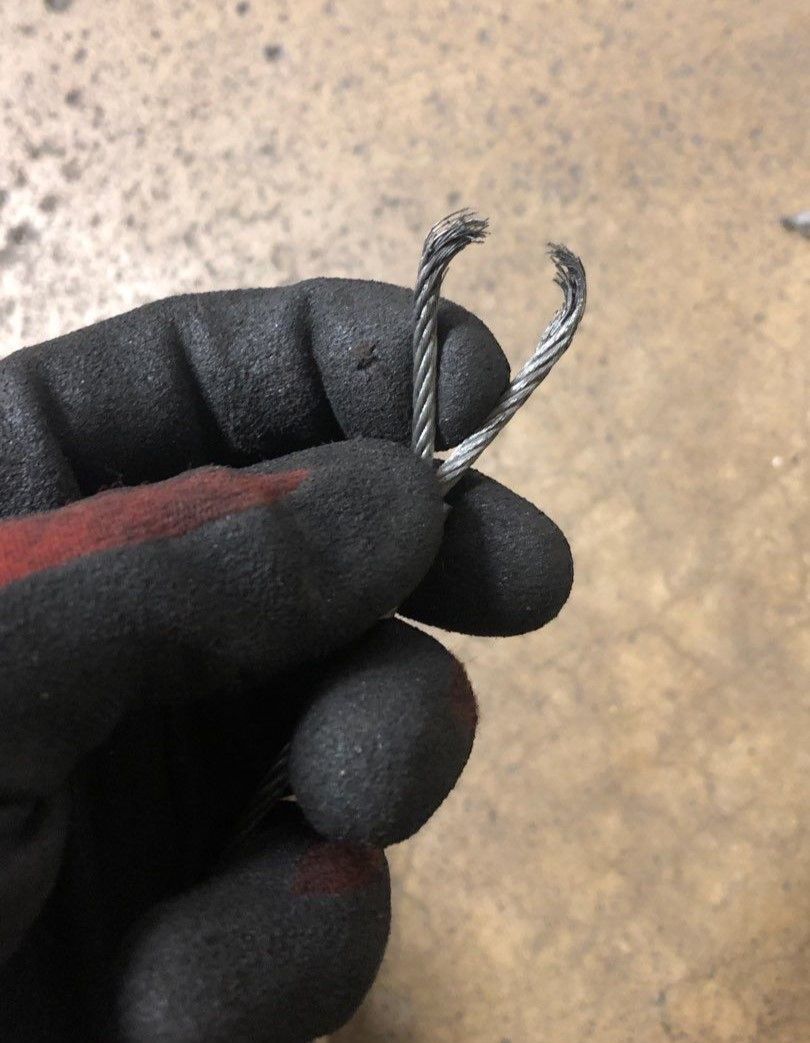 close up of a garage door cable that snapped in two at the eye