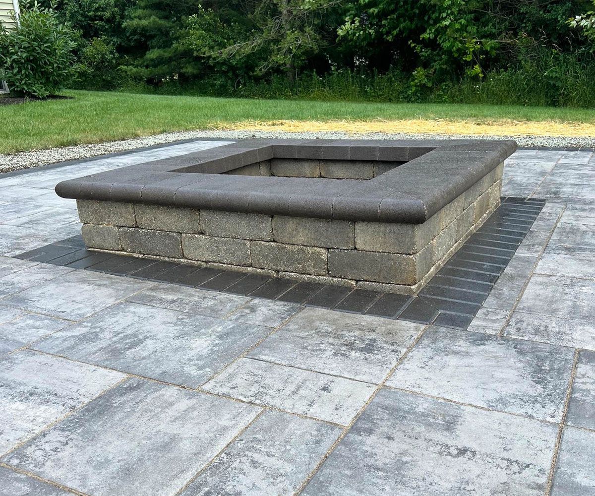 Unilock square fire pit woodburning on Bath, OH backyard paver patio