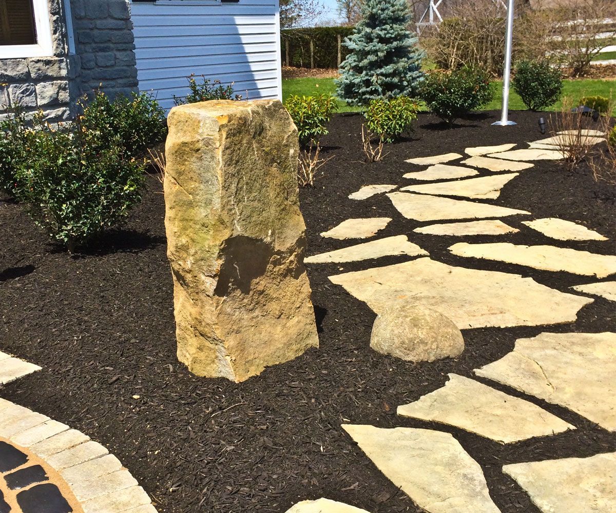 Natural barnstone column water feature bubbler fountain by flagstone patio in Fairlawn, OH landscape