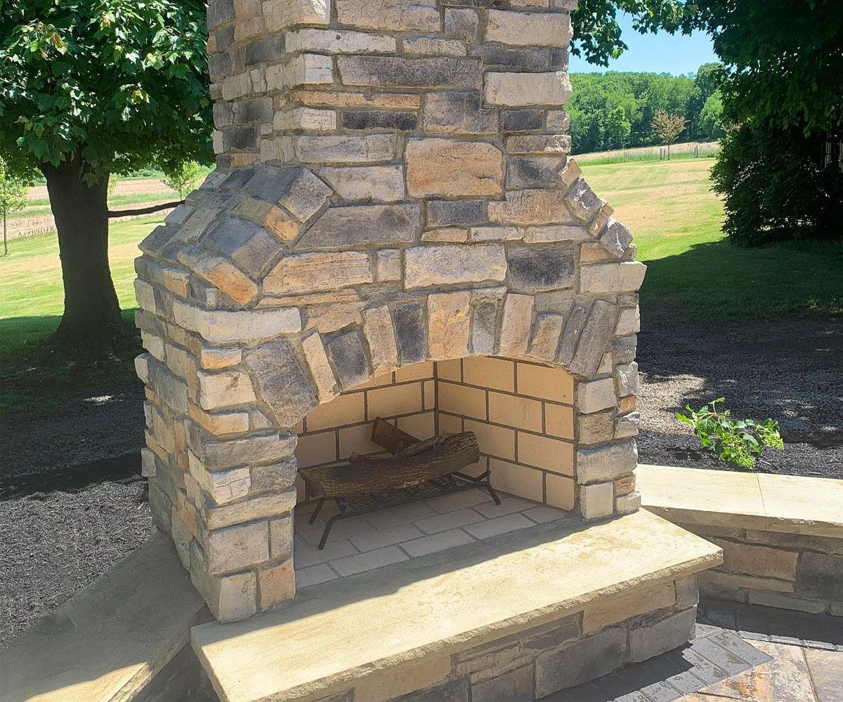 Custom outdoor stone fireplace in Bath, OH designed and installed by Chidsey Landscape & Design
