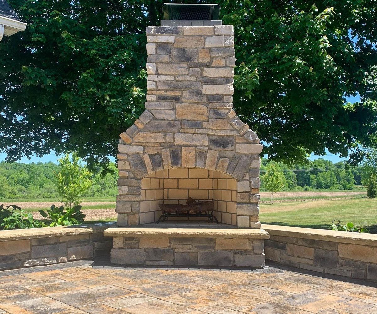 Stone outdoor fireplace on 90 degree corner of Brecksville, Ohio backyard patio.