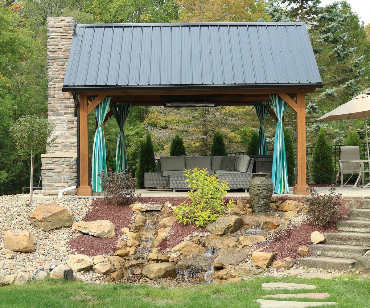 Durable weather resistant timber wood pavilion covering outdoor fireplace near Medina home waterfall