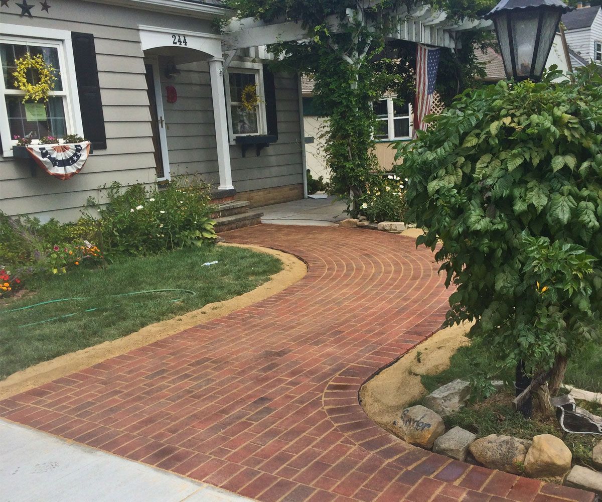 Custom paving stone walkway at front entrance of Bath, OH home with herringbone pattern.