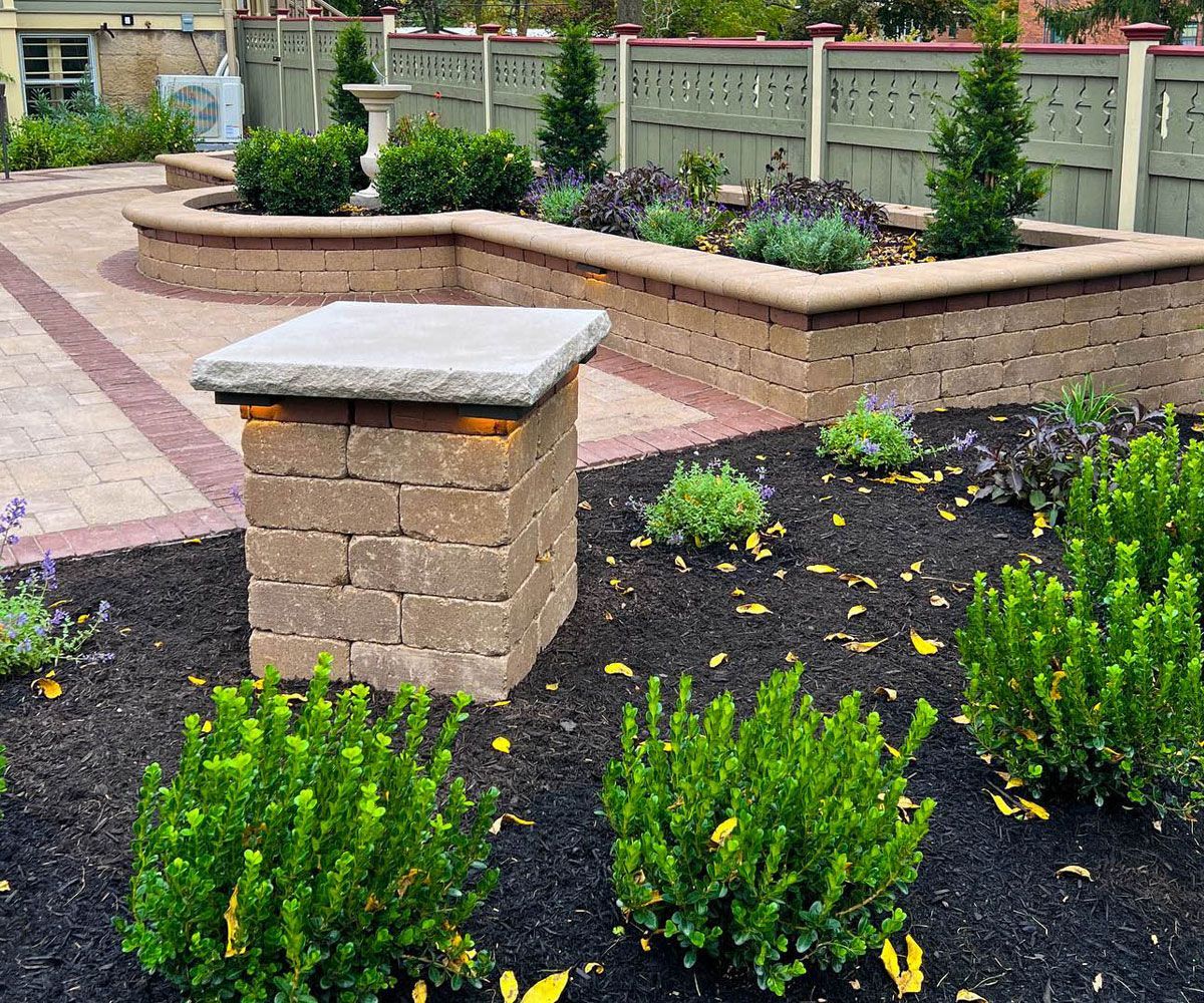 Softscape plantings with evergreens, flowers, and shrubs that unify Medina, Ohio backyard outdoor rooms and retaining wall