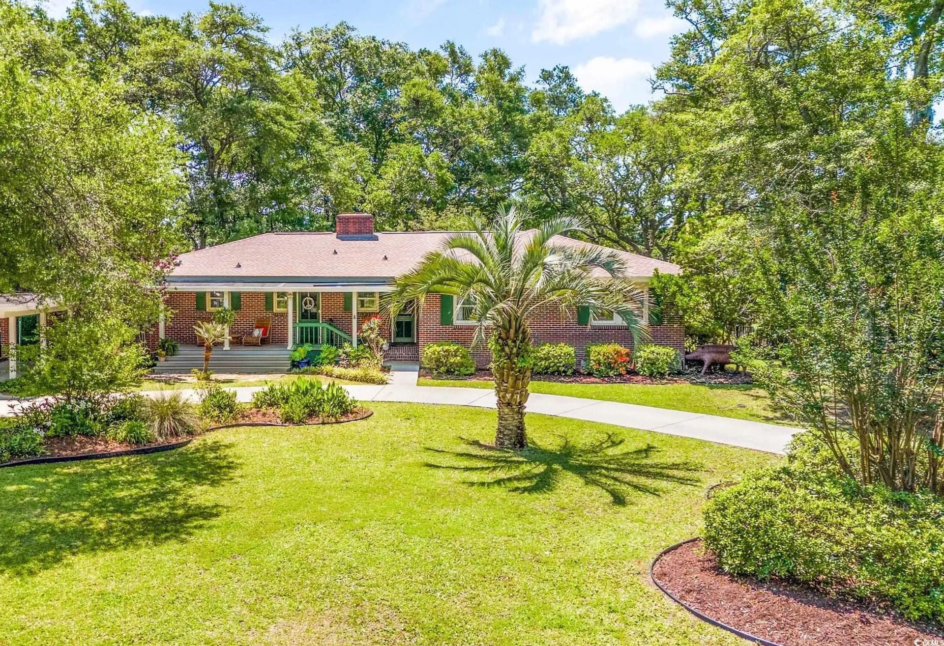 a yellow house with palm trees in front of it
