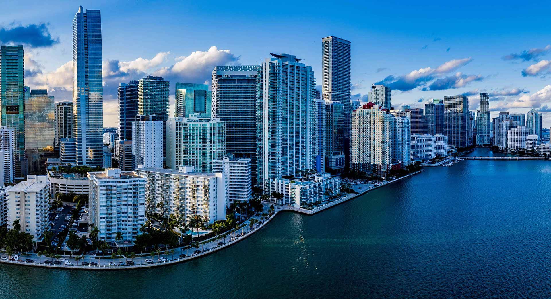 An aerial view of a city skyline with a body of water in the foreground.