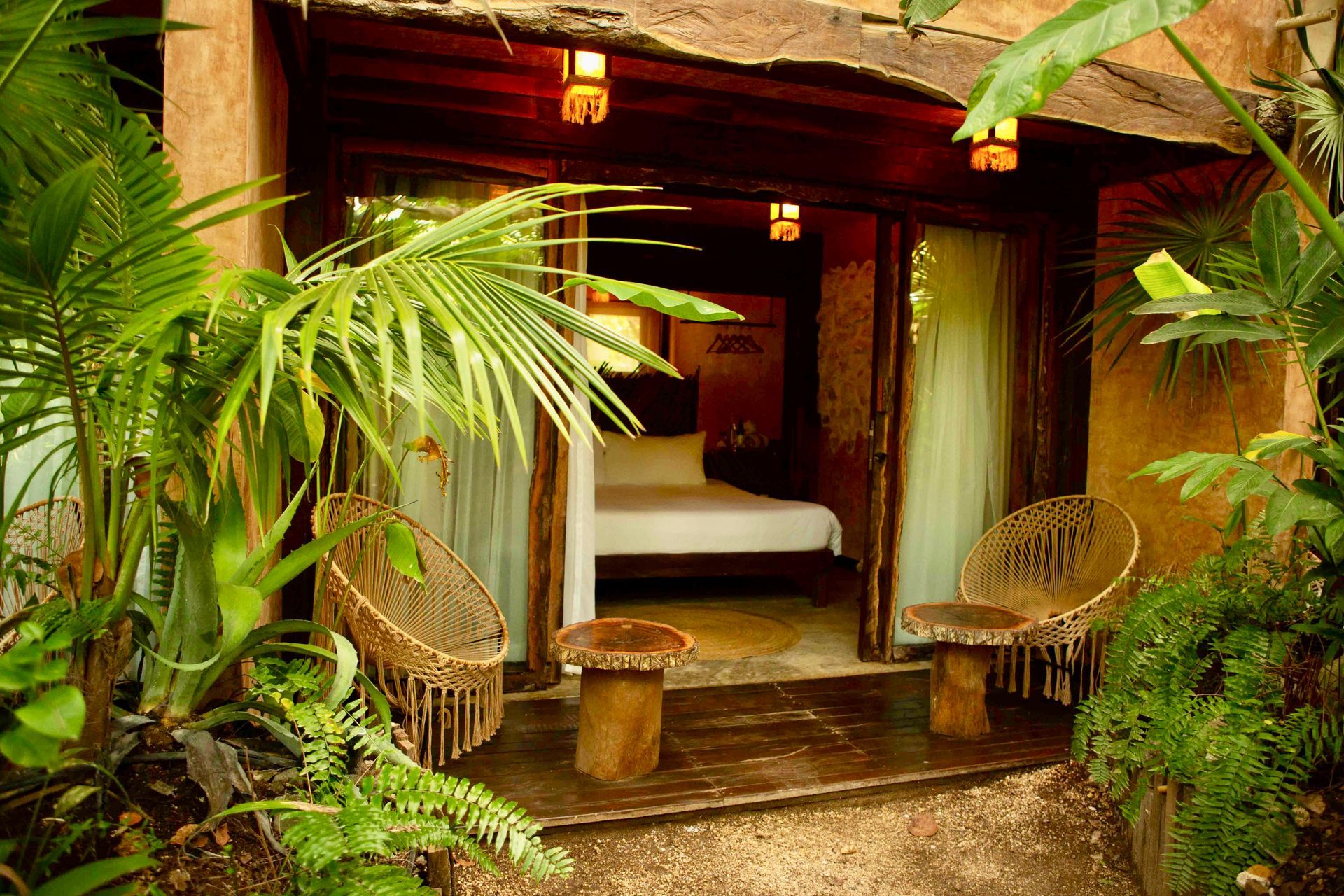A bedroom with a bed and two chairs in the jungle