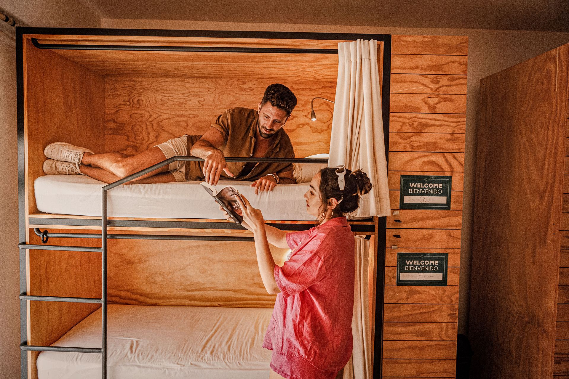 A man and a woman are laying on bunk beds in a room.