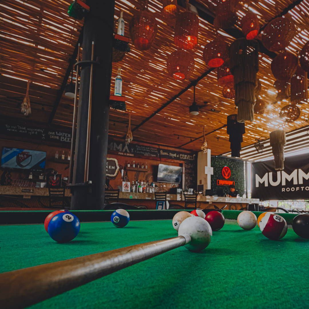 A pool table in a bar with a sign that says mummy