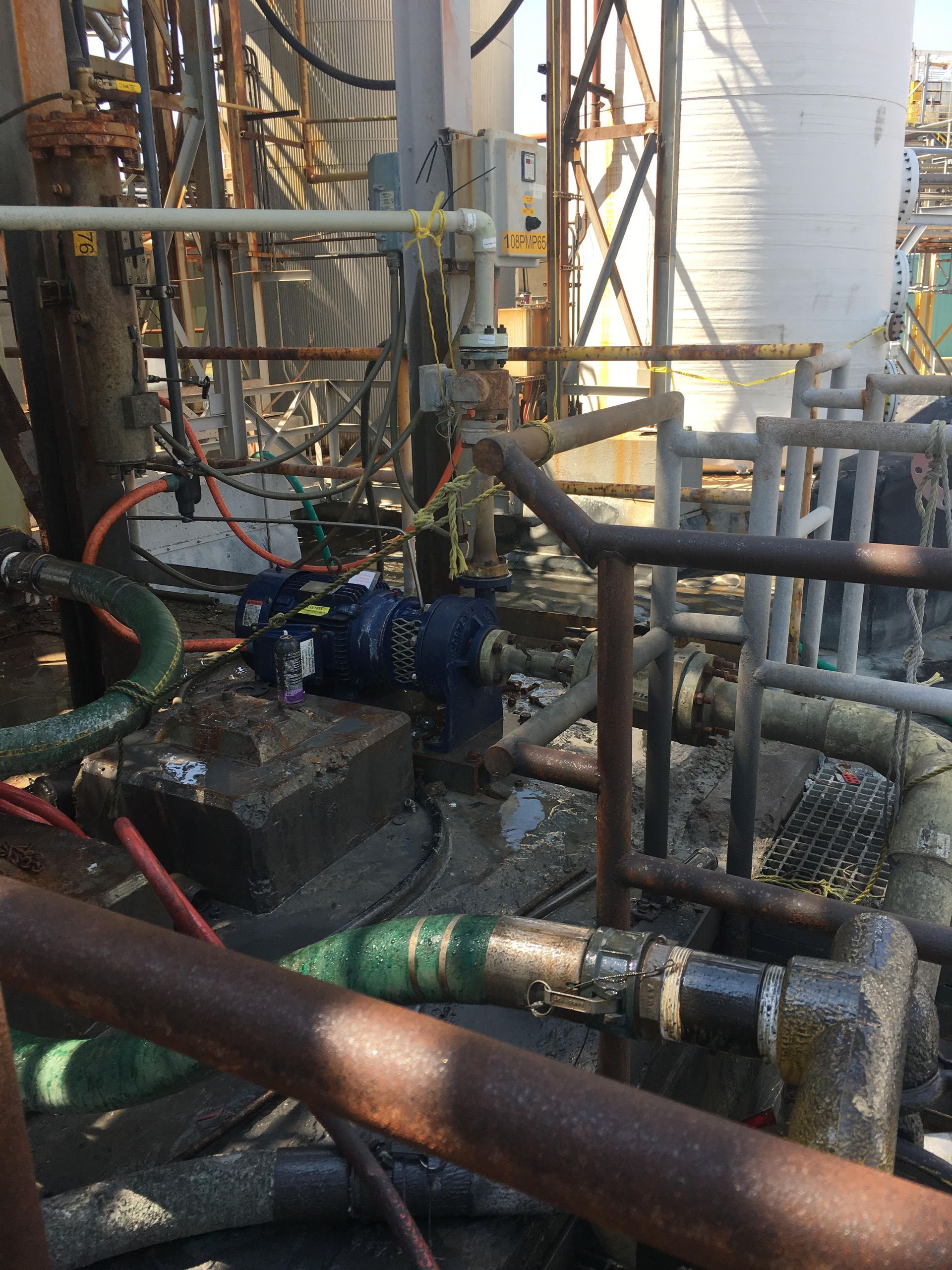 A bunch of pipes are sitting on the ground in a factory.