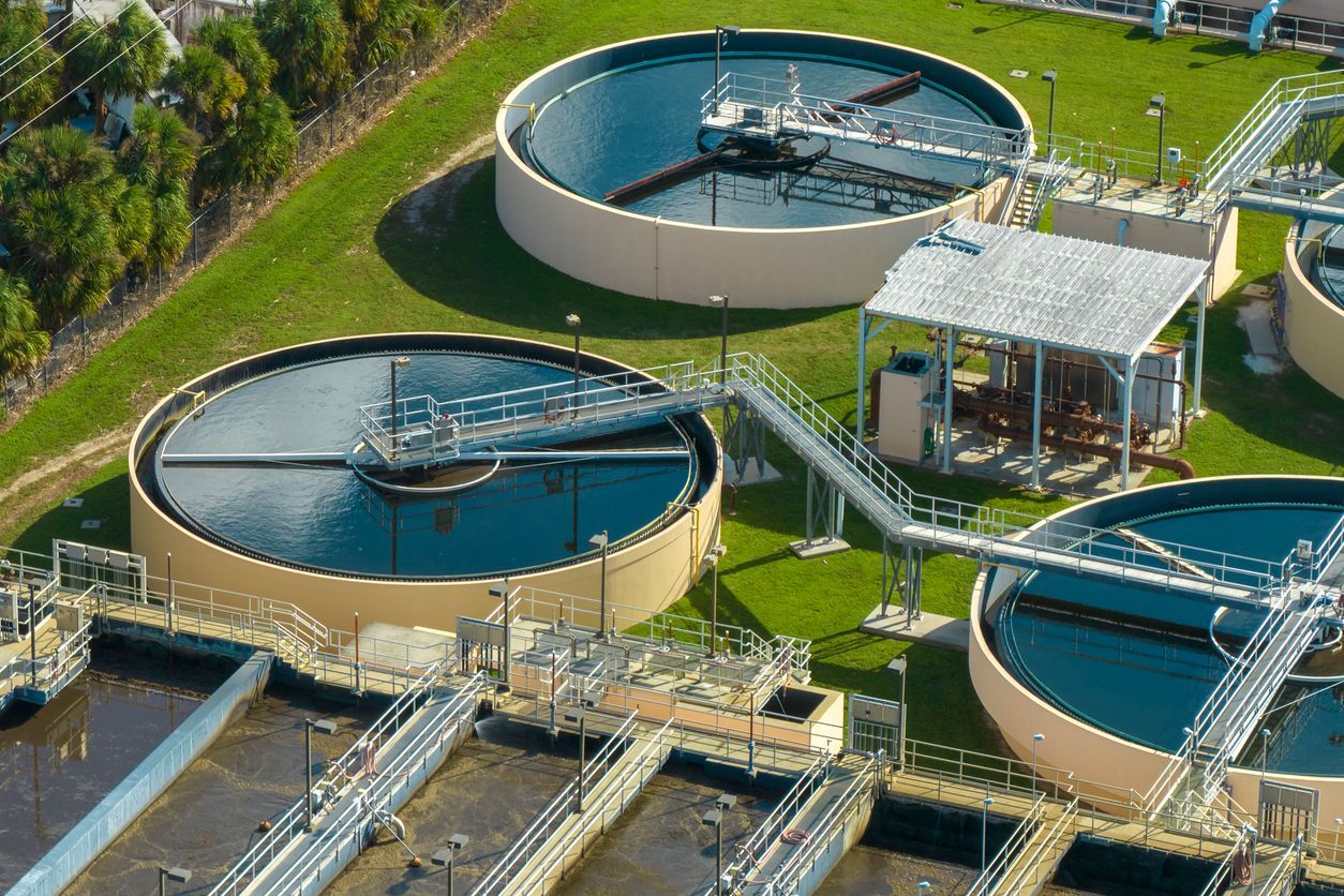 An aerial view of a water treatment plant with a lot of tanks and pipes.