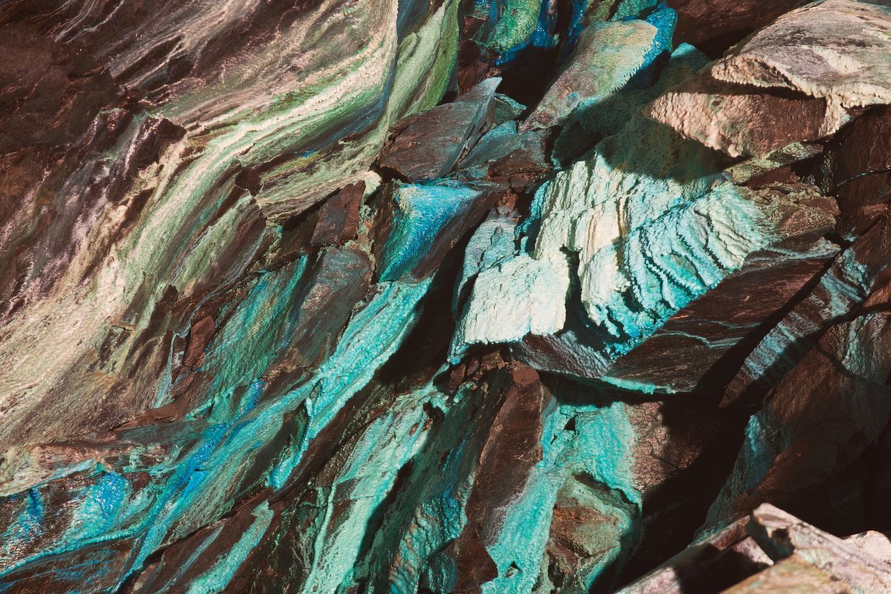 A close up of a painting of a rock with blue and brown colors