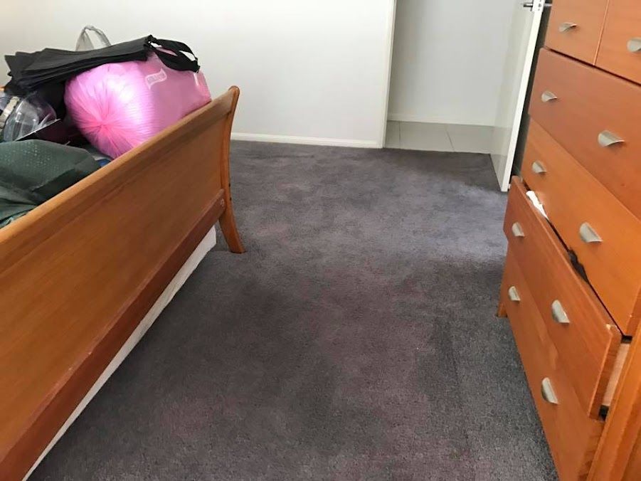 A Bedroom With a Wooden Bed and a Dresser — Encore Carpet Professionals in Mudgeeraba, QLD