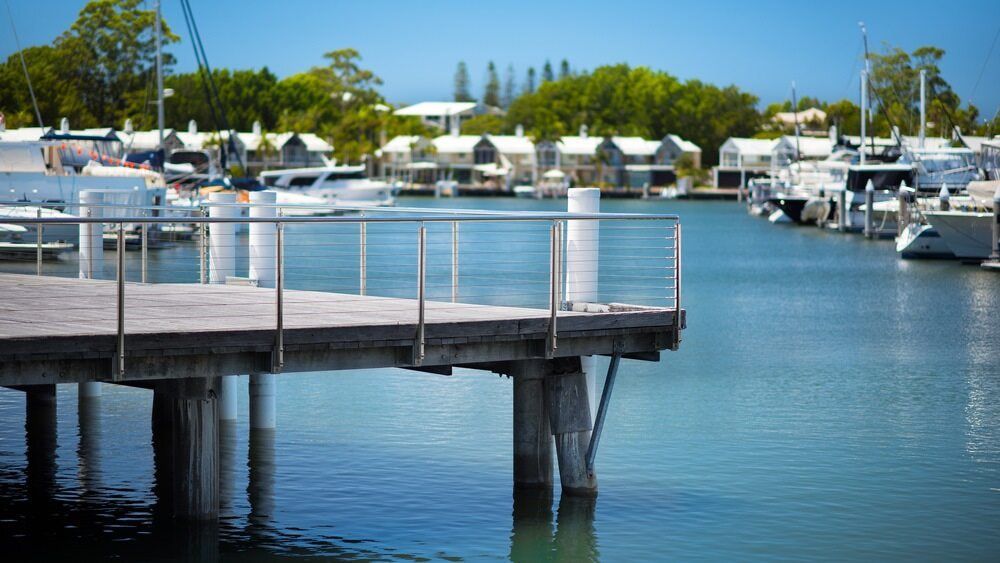 A Dock With Boats Docked At A Marina In The Background — Encore Carpet Professionals in Hope Island, QLD