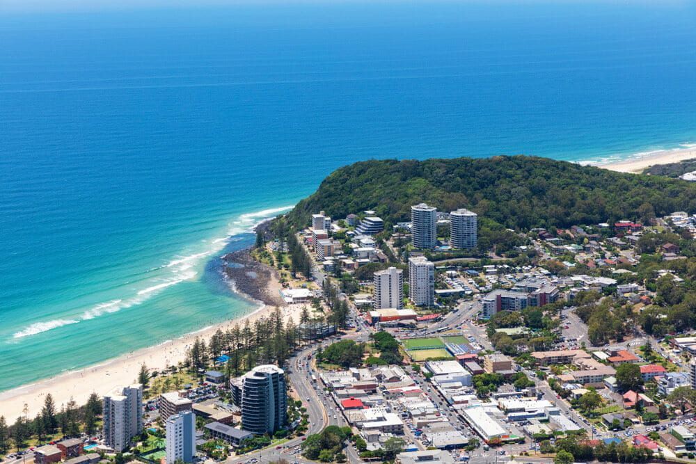 An Aerial View Of A City Next To A Beach And Ocean — Encore Carpet Professionals in Burleigh, QLD