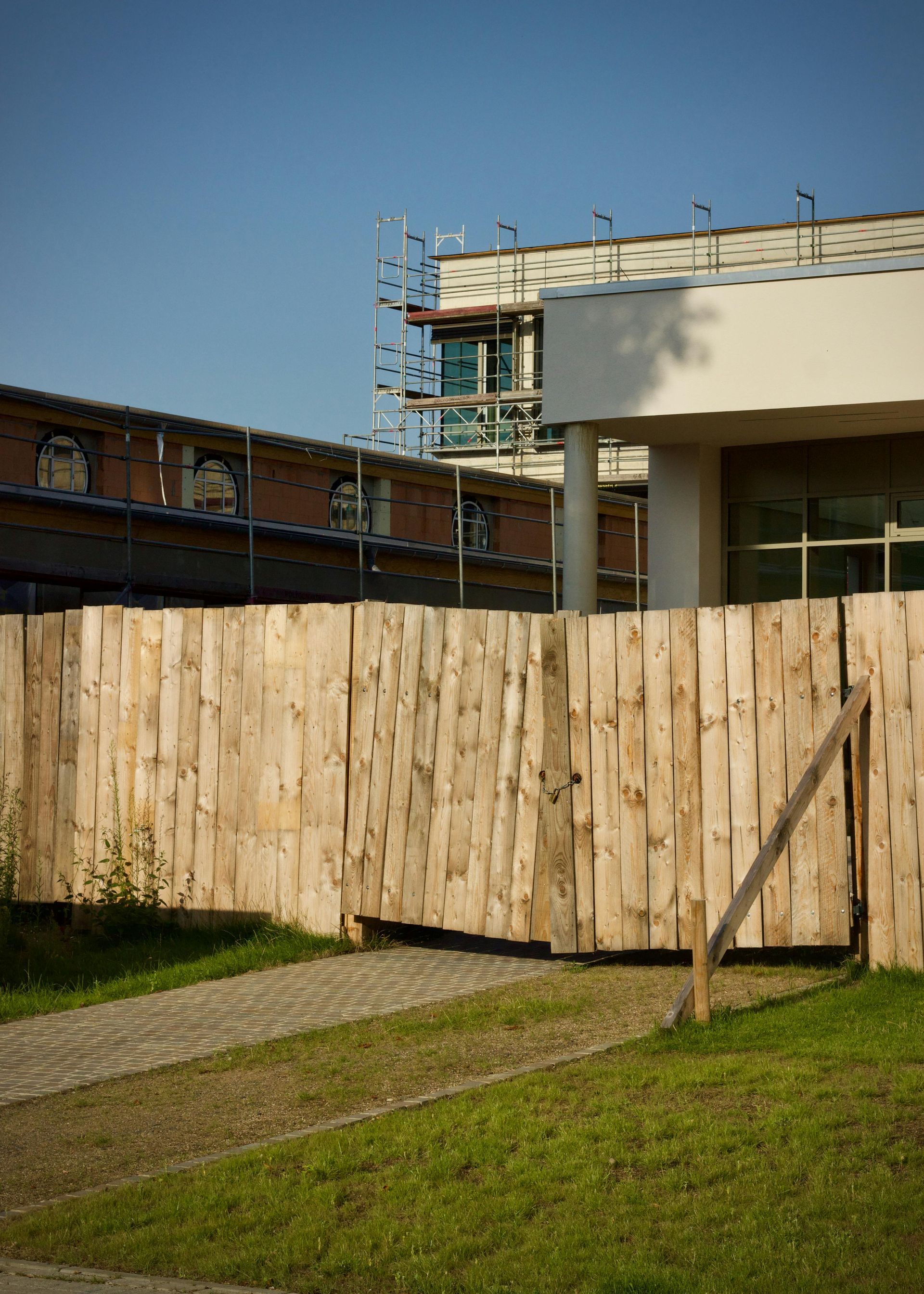 Wooden fence in front of a building under construction on a sunny day