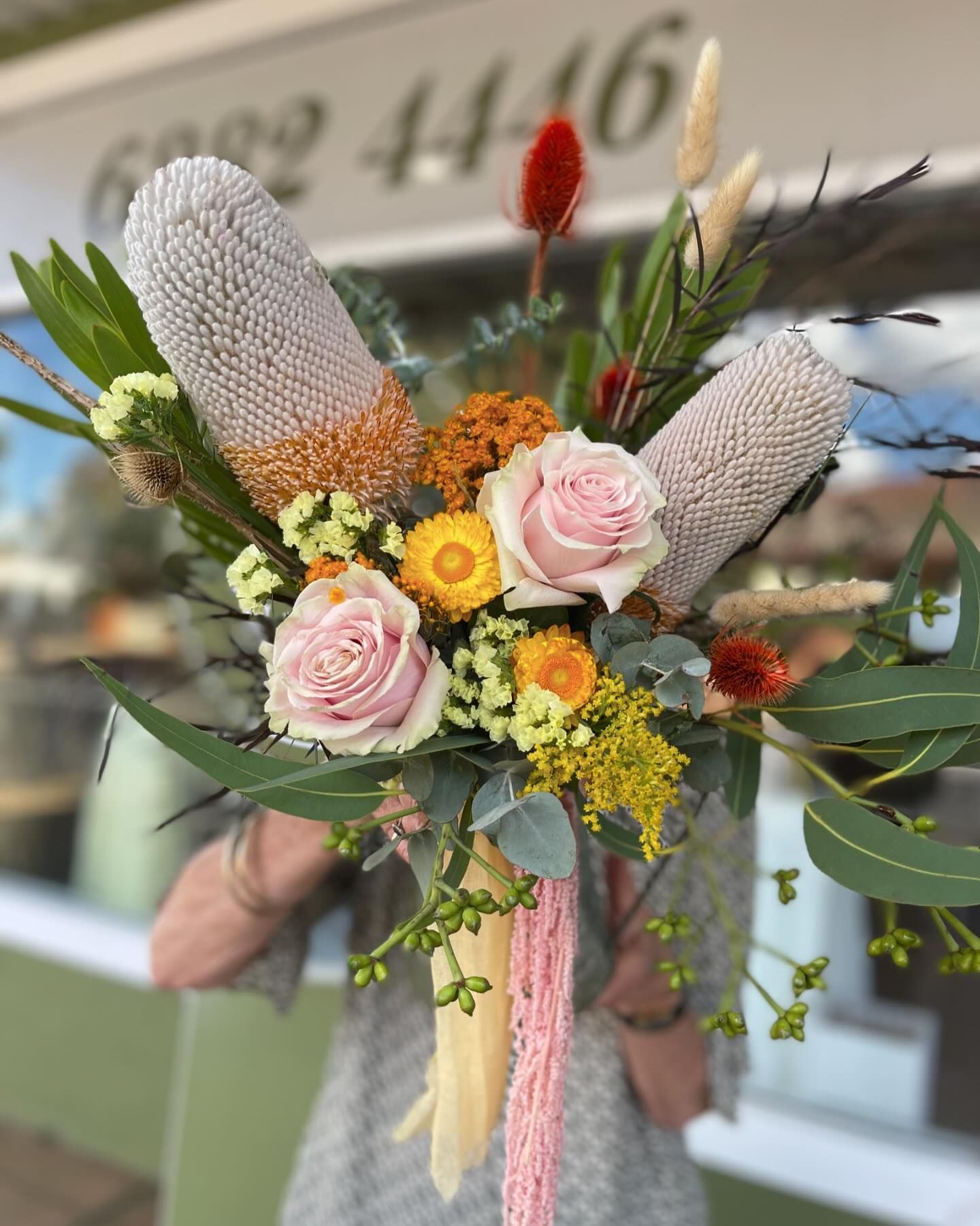 Woman Holding a Bouquet of Pink Roses with Eucalyptus Leaves — Denise's Flower Studio In Gilgandra, NSW