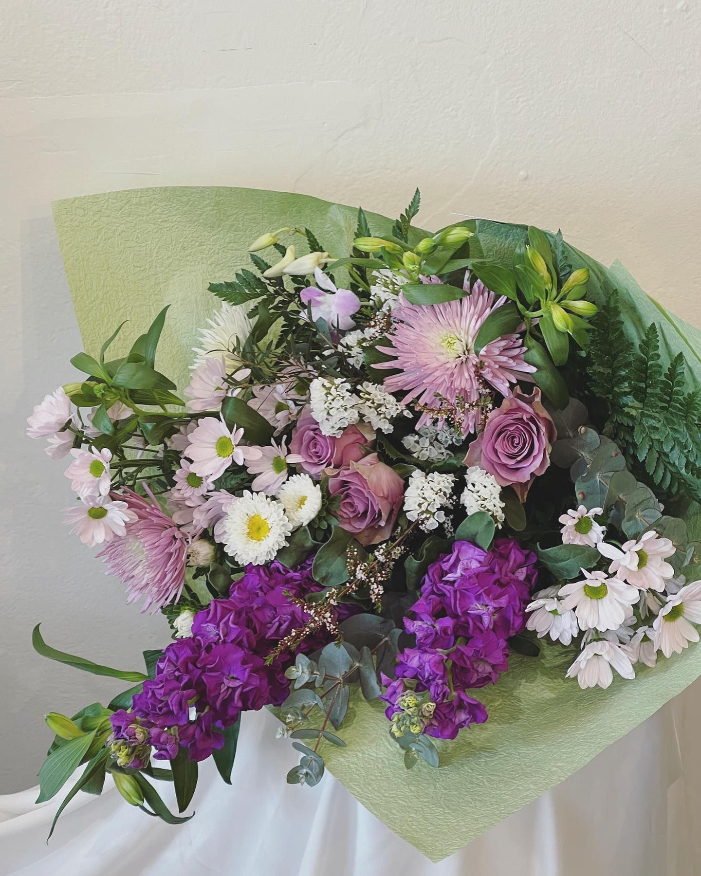 Bouquet of Purple and Pink Flowers Wrapped in Green Paper — Denise's Flower Studio In Gilgandra, NSW
