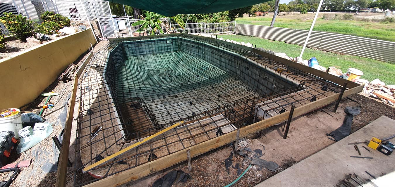 A Large Swimming Pool is Being Built in a Backyard — NQ Tropical Pools & Renovations in Cranbrook, QLD