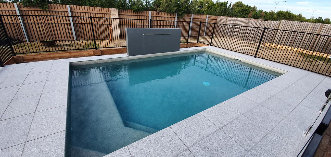 A Small Swimming Pool is Surrounded by a Fence in a Backyard — NQ Tropical Pools & Renovations in Cranbrook, QLD