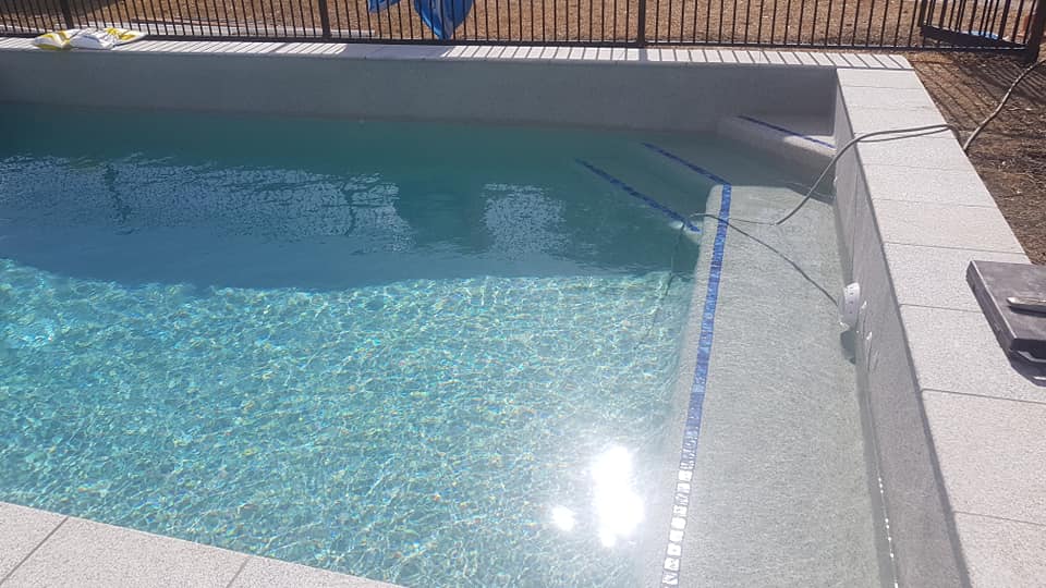 A Large Swimming Pool With a Fence Around It and a Lot of Water — NQ Tropical Pools & Renovations in Cranbrook, QLD
