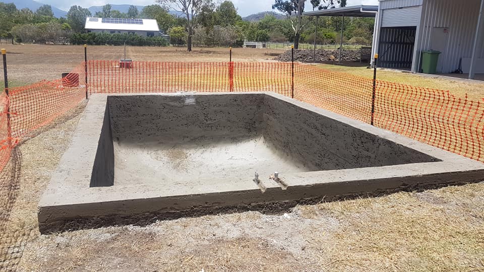 A Large Concrete Pool is Being Built in a Dirt Field — NQ Tropical Pools & Renovations in Cranbrook, QLD