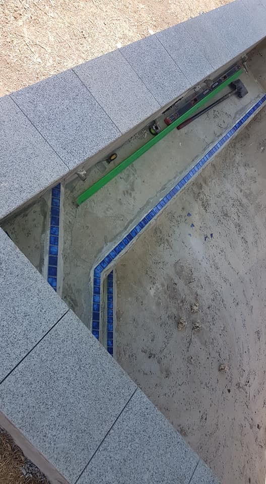 A Swimming Pool is Being Built With Tiles and a Green Level — NQ Tropical Pools & Renovations in Cranbrook, QLD