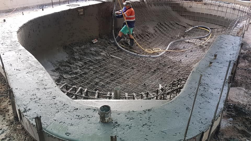 A Man is Working on a Large Concrete Pool — NQ Tropical Pools & Renovations in Bowen, QLD