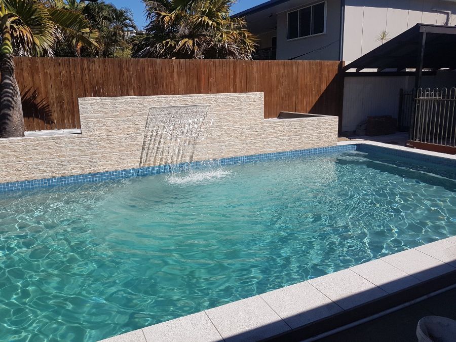 There is a Waterfall in the Middle of the Pool — NQ Tropical Pools & Renovations in Cranbrook, QLD