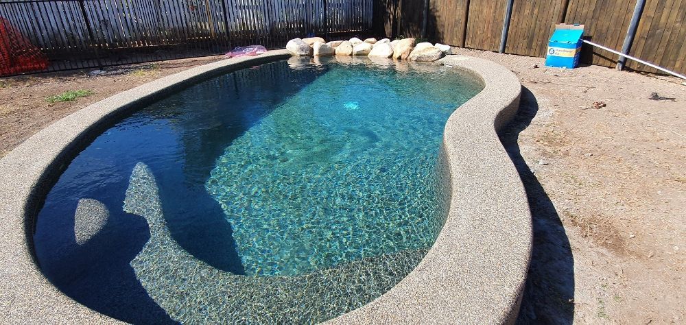 A Small Swimming Pool in a Backyard With a Fence in the Background — NQ Tropical Pools & Renovations in Cranbrook, QLD