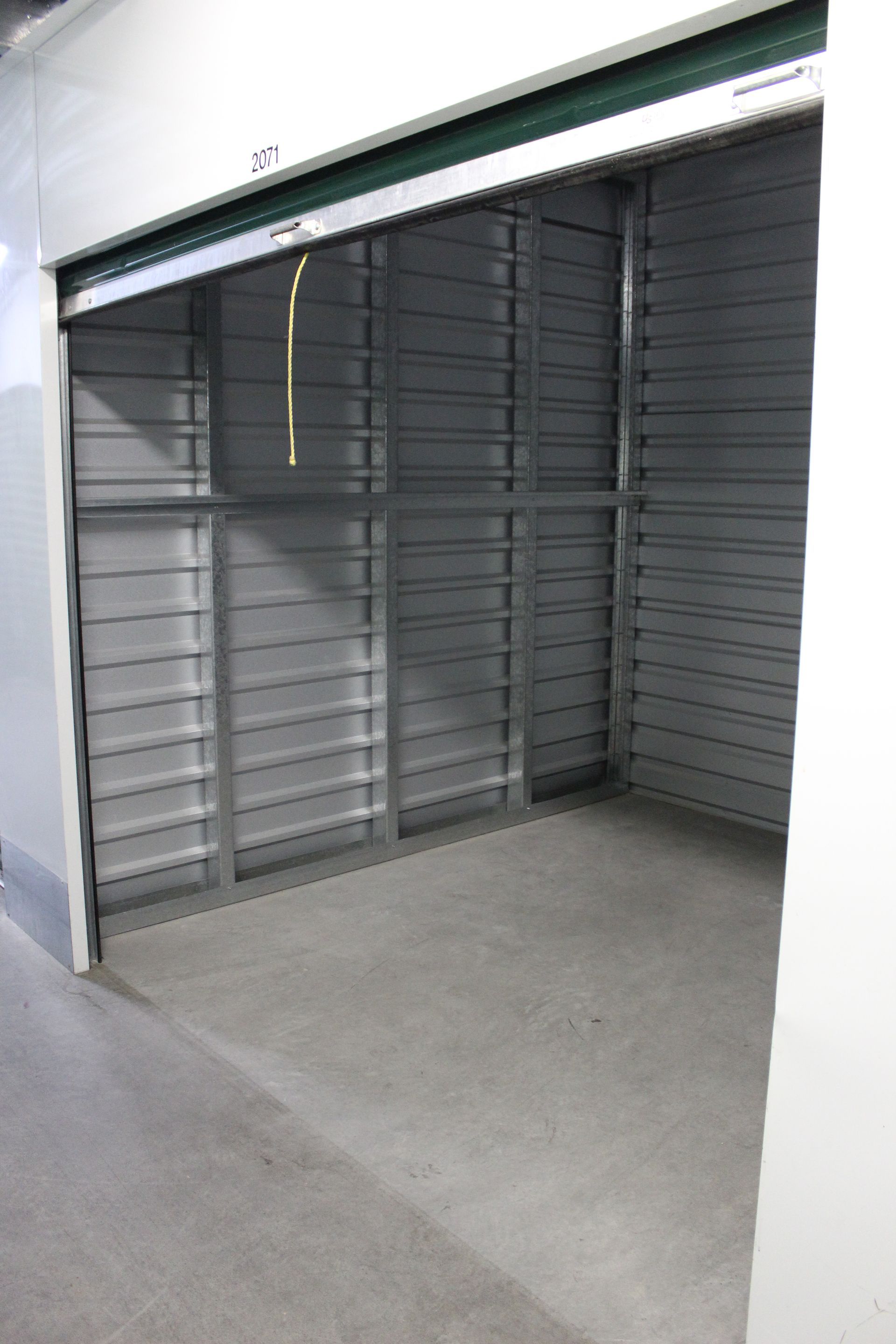 Empty storage unit with a gray metal door and interior.